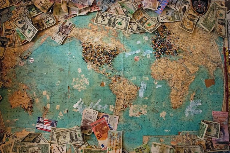 Map of the world. surrounded by currencies of different kinds.